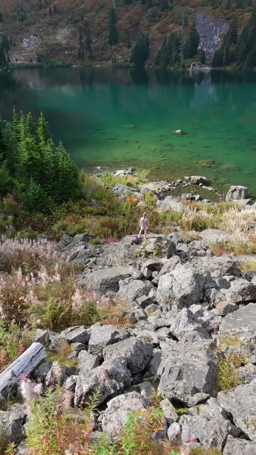 Aerial view of a turquoise alpine lake above a talus field